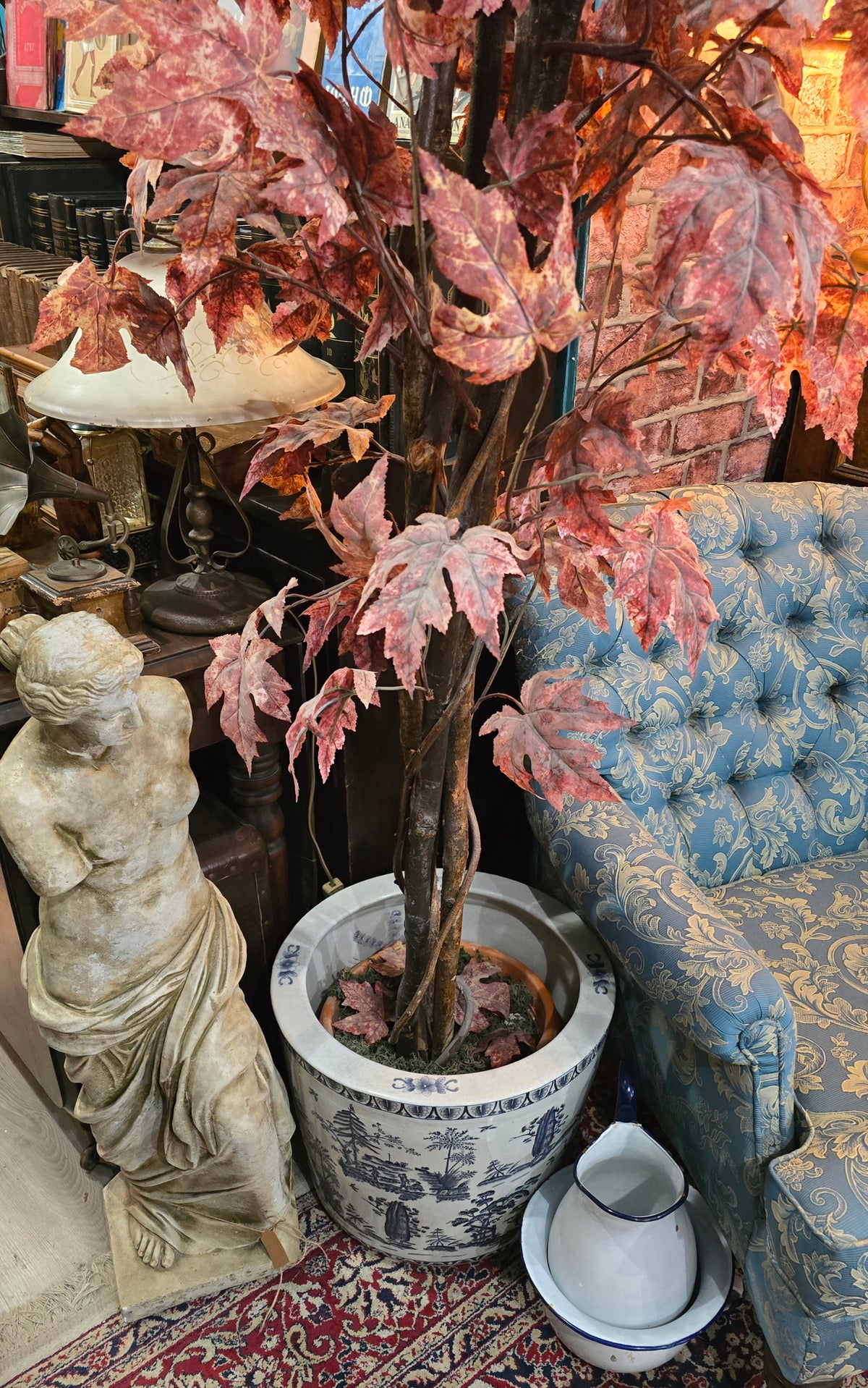 Artificial maple tree with maroon autumn-colored foliage with , blue-and-white porcelain cache-pot