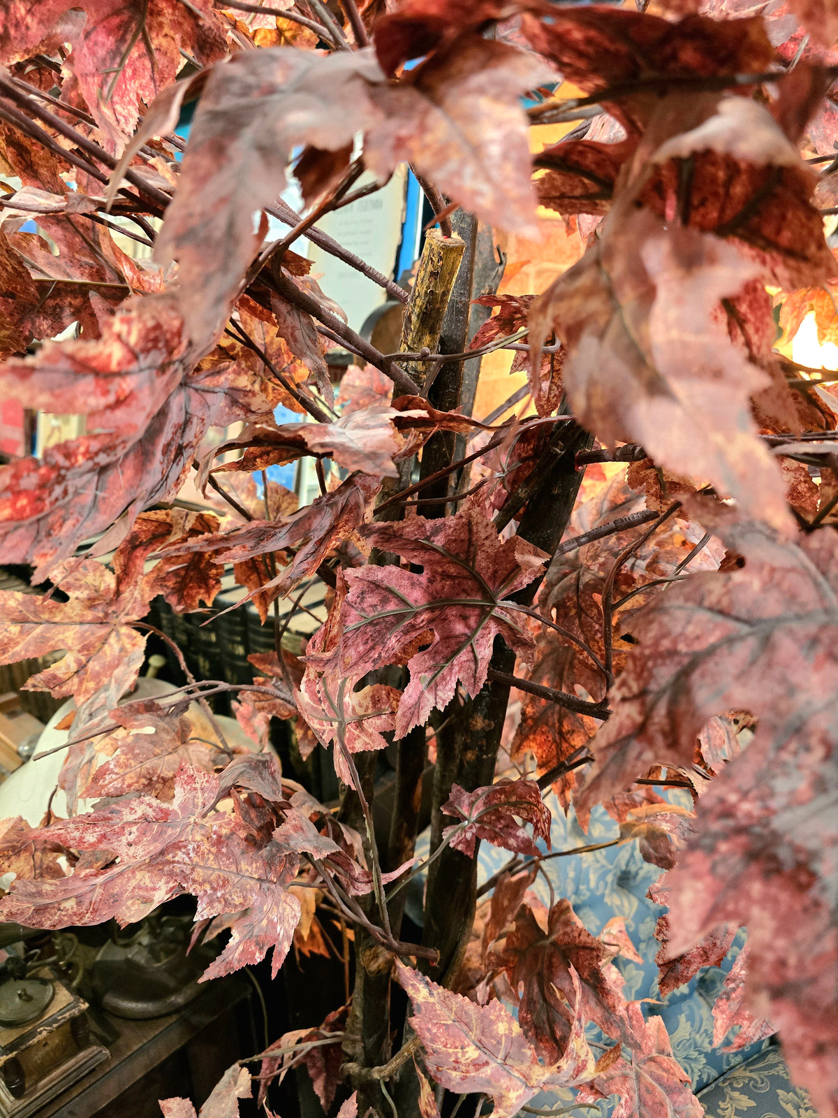 Artificial maple tree with maroon autumn-colored foliage with , blue-and-white porcelain cache-pot
