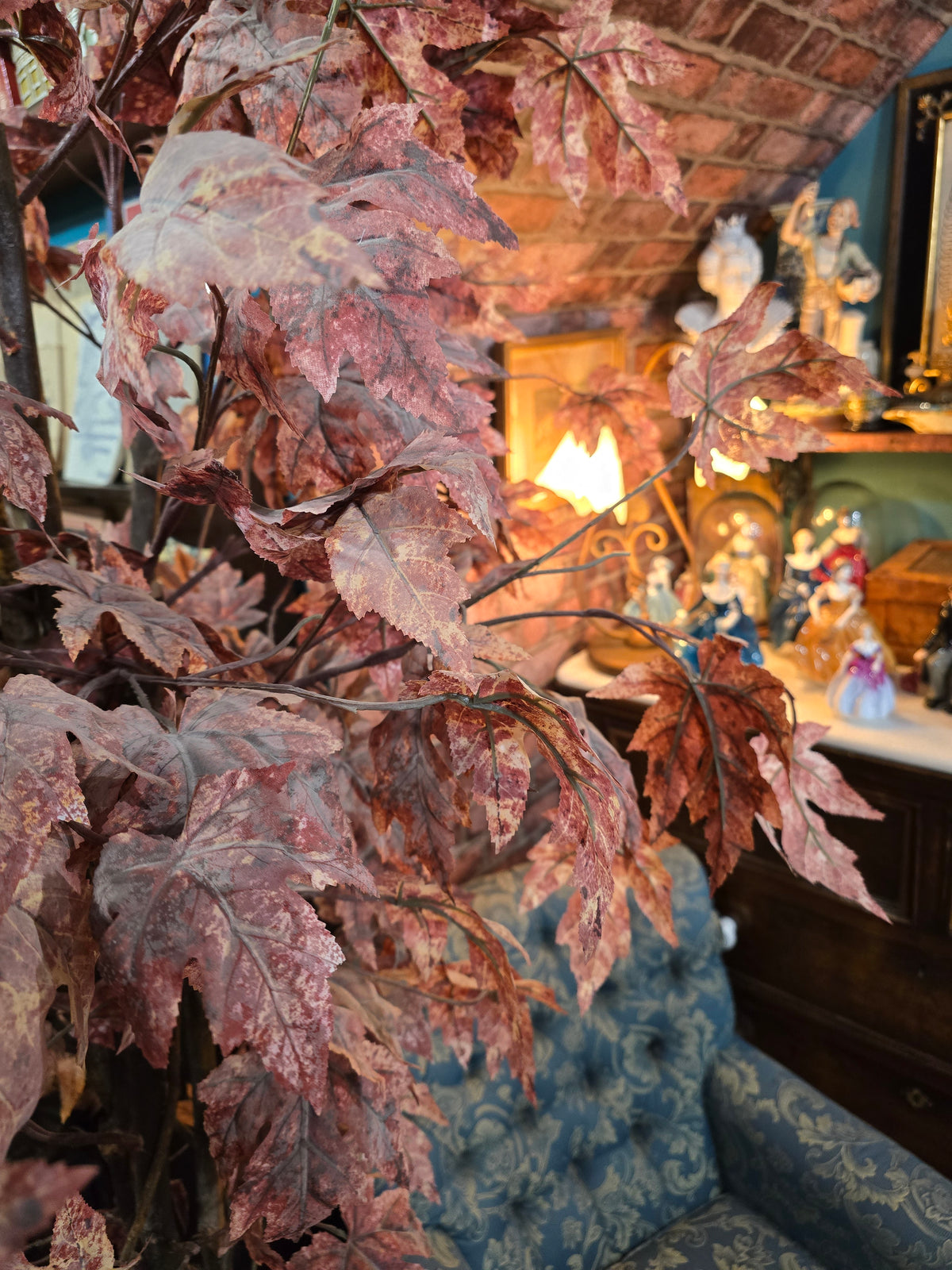 Artificial maple tree with maroon autumn-colored foliage with , blue-and-white porcelain cache-pot