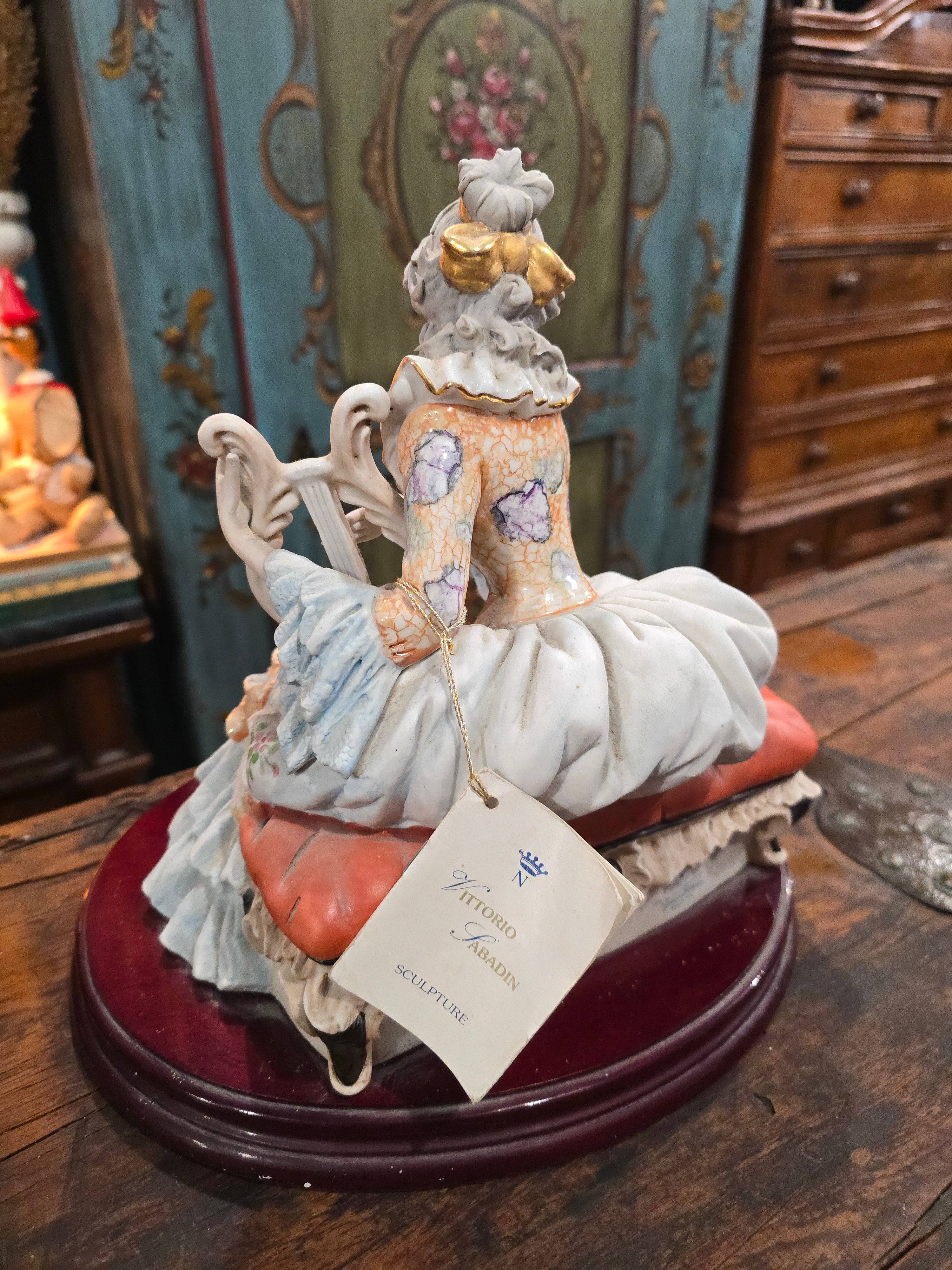 Vittorio Sabadin Italian porcelain figurine titled "Dame à la lyre"featuring a woman in a Rococo-style dress.
