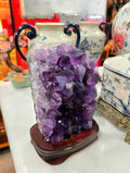 Vintage amethyst crystal cluster on a wooden stand