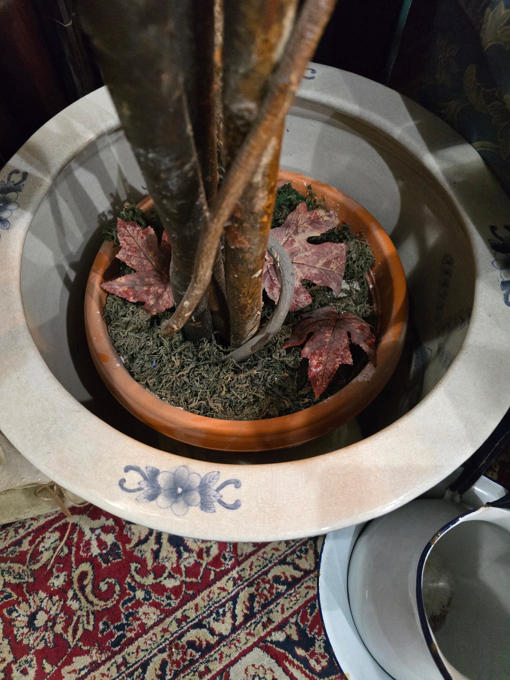 Artificial maple tree with maroon autumn-colored foliage with , blue-and-white porcelain cache-pot