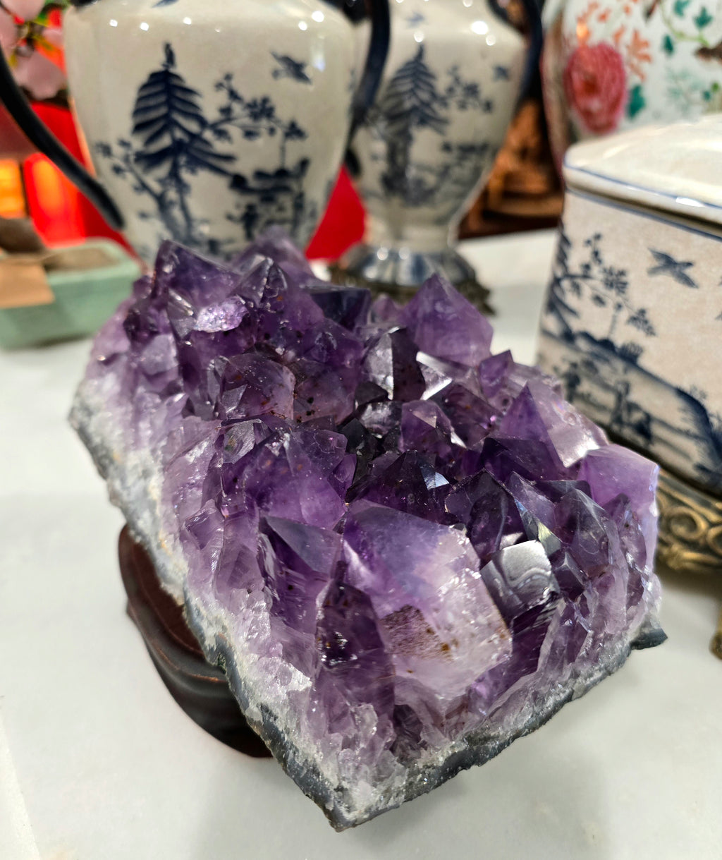 Vintage amethyst crystal cluster on a wooden stand