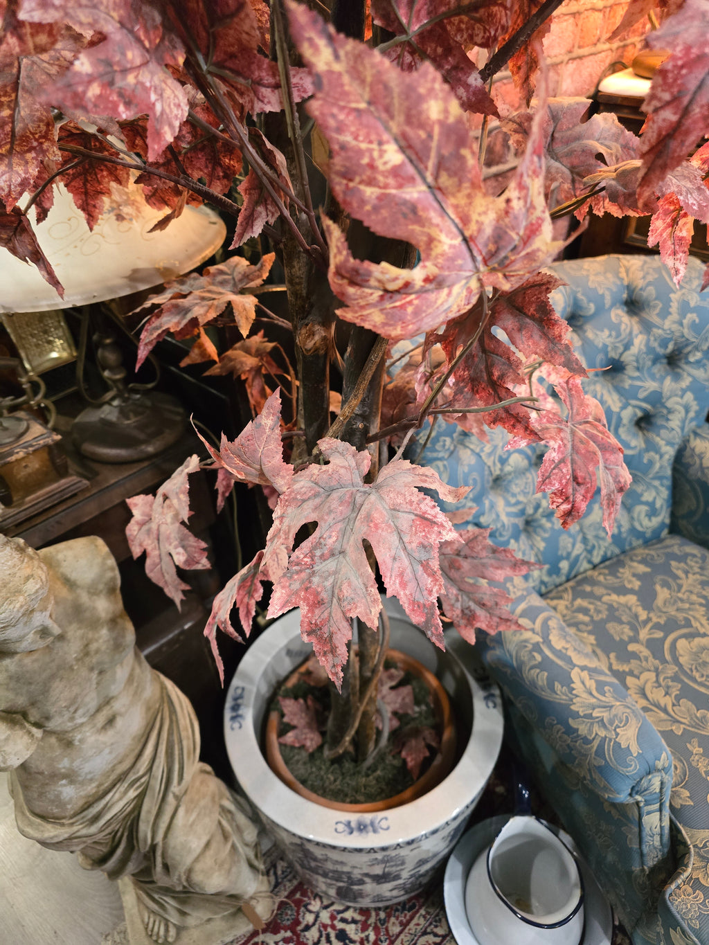 Artificial maple tree with maroon autumn-colored foliage with , blue-and-white porcelain cache-pot
