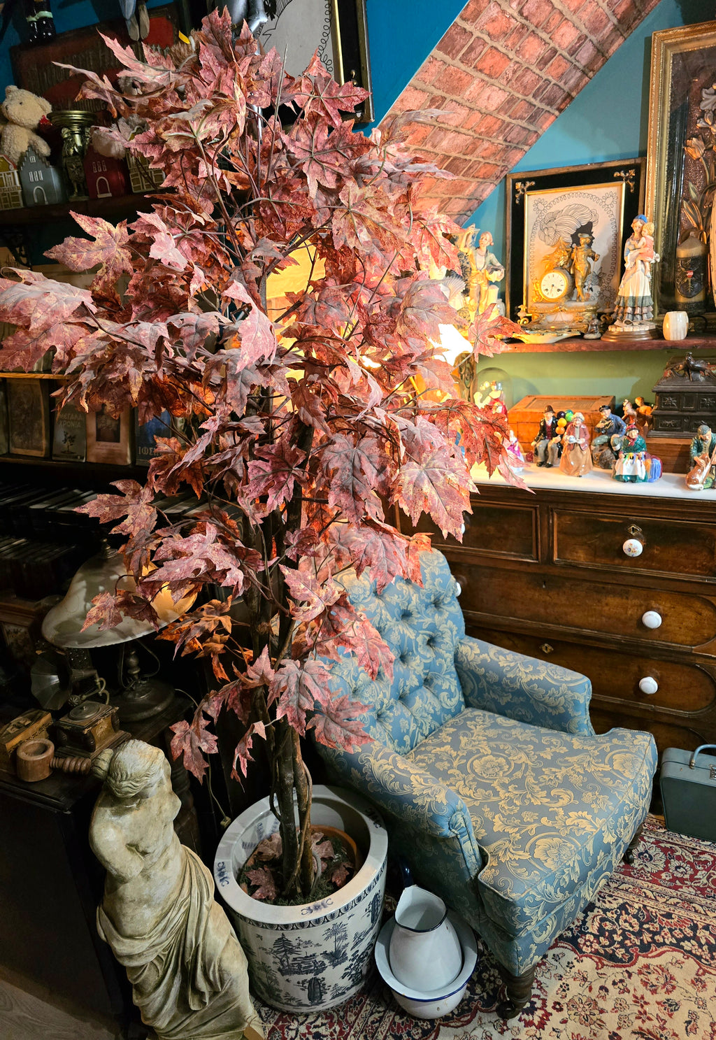 Artificial maple tree with maroon autumn-colored foliage with , blue-and-white porcelain cache-pot