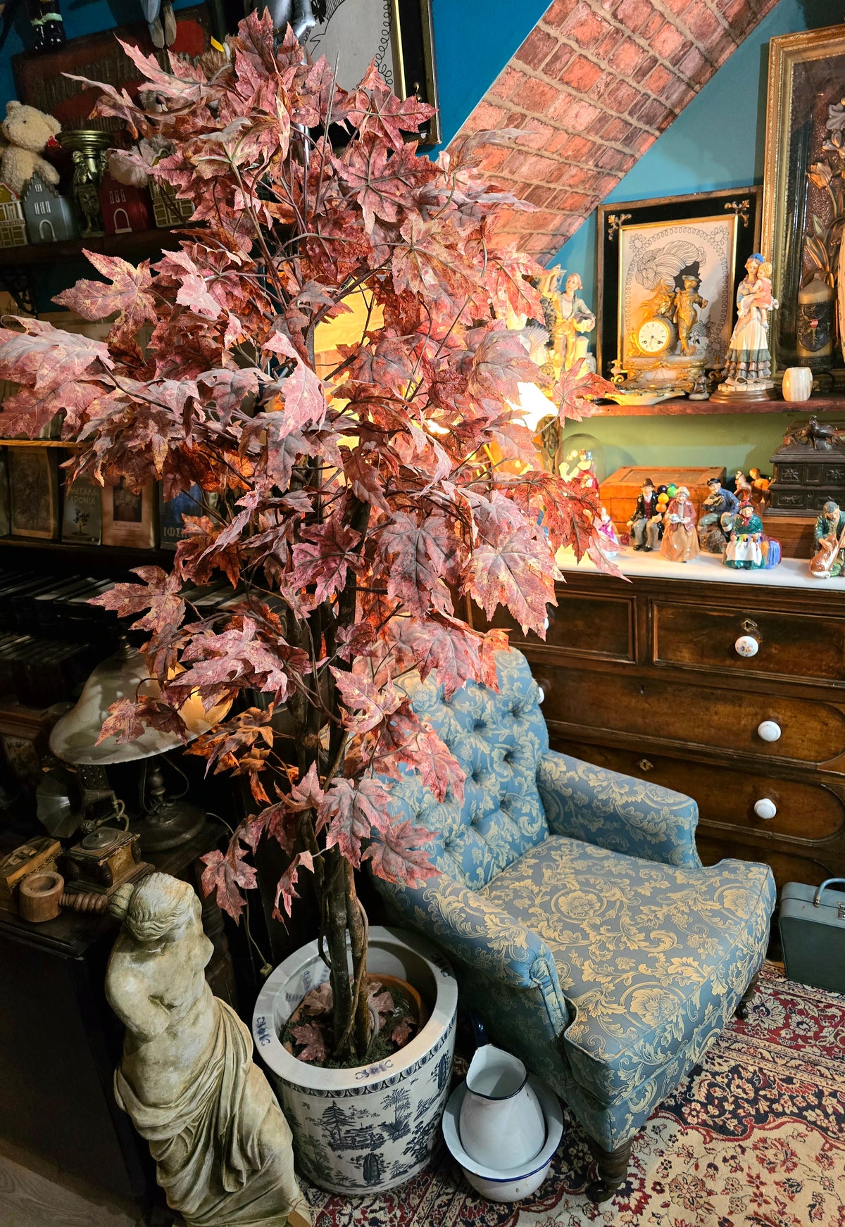 Artificial maple tree with maroon autumn-colored foliage with , blue-and-white porcelain cache-pot