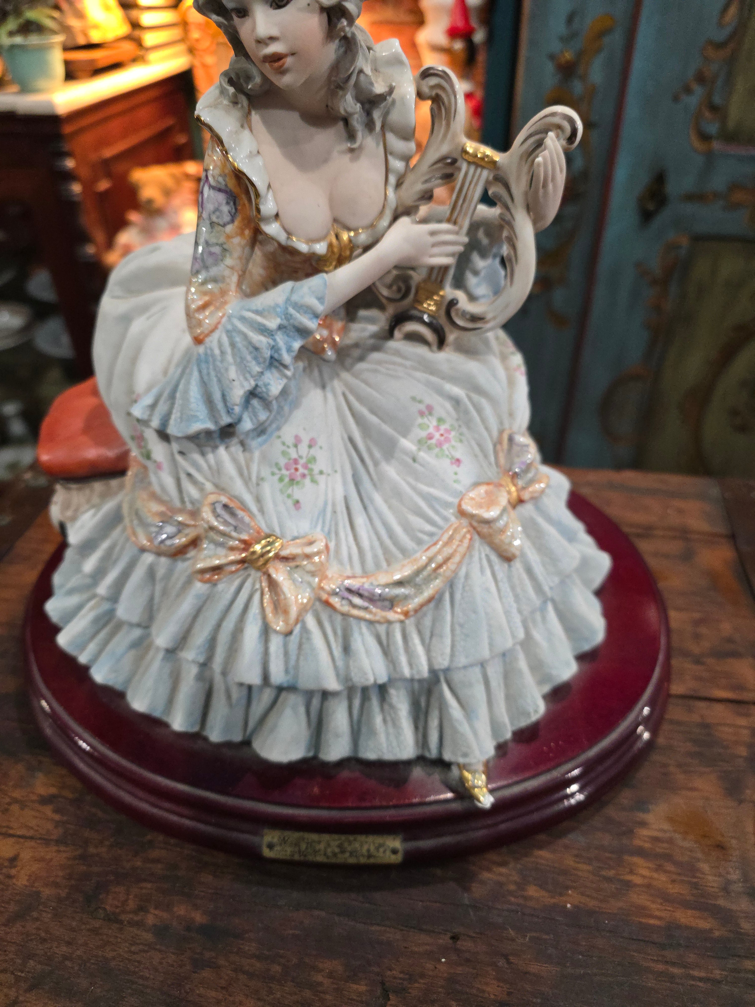 Vittorio Sabadin Italian porcelain figurine titled "Dame à la lyre"featuring a woman in a Rococo-style dress.