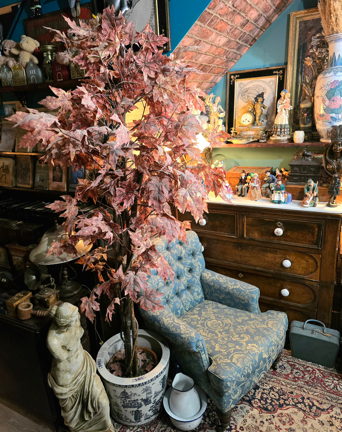 Artificial maple tree with maroon autumn-colored foliage with , blue-and-white porcelain cache-pot