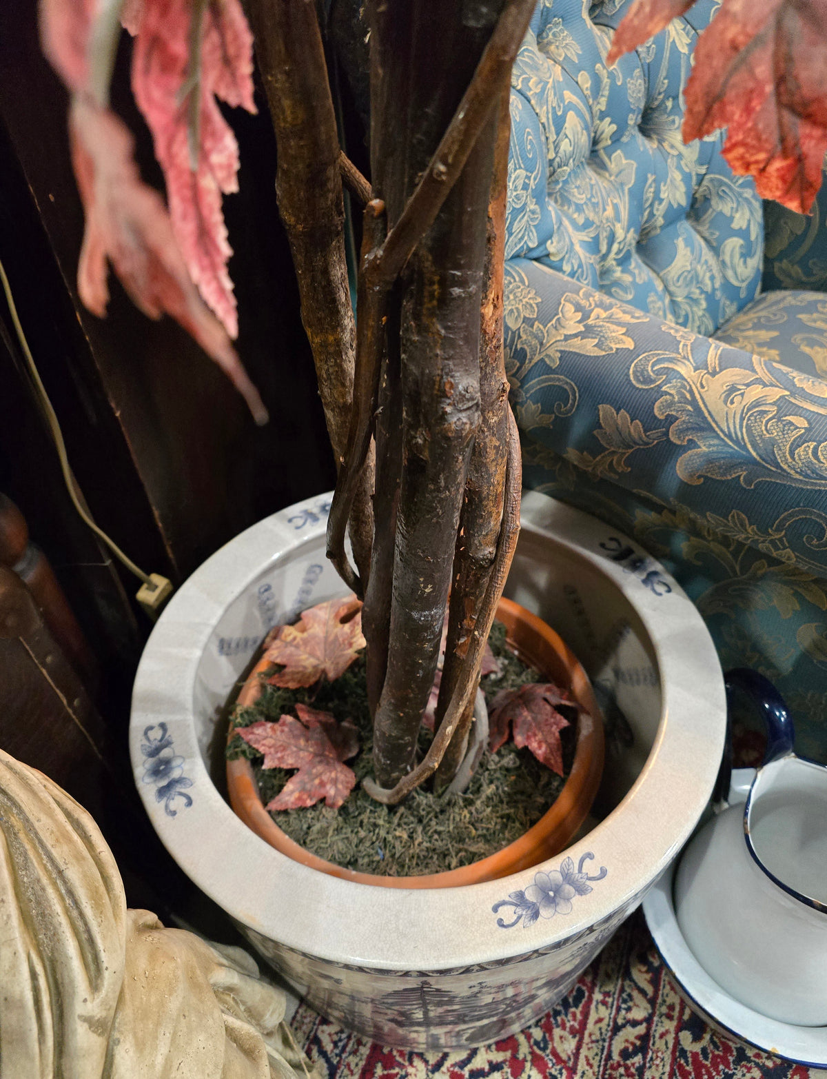 Artificial maple tree with maroon autumn-colored foliage with , blue-and-white porcelain cache-pot