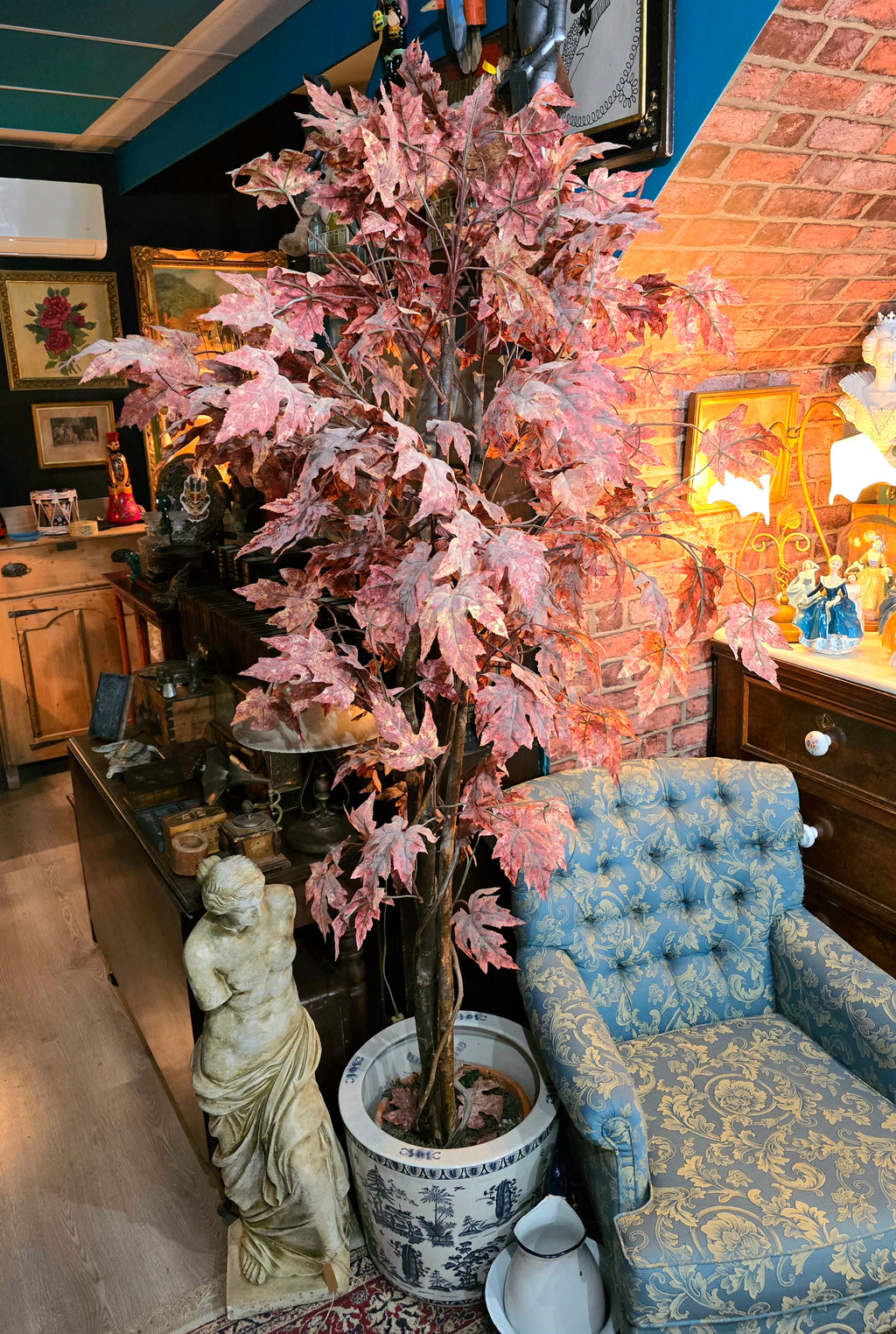 Artificial maple tree with maroon autumn-colored foliage with , blue-and-white porcelain cache-pot