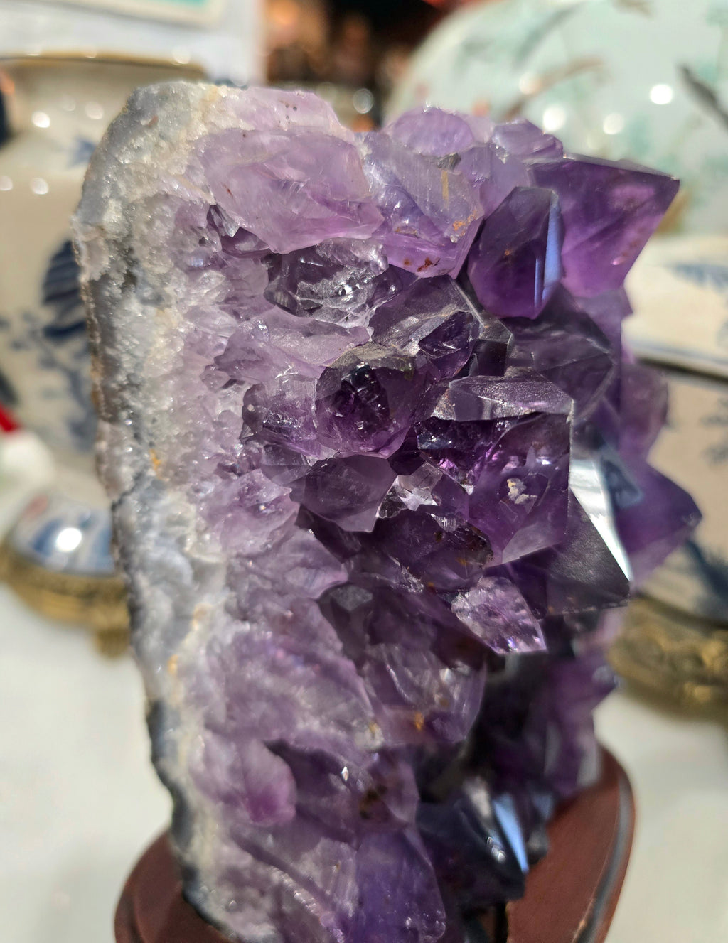 Vintage amethyst crystal cluster on a wooden stand