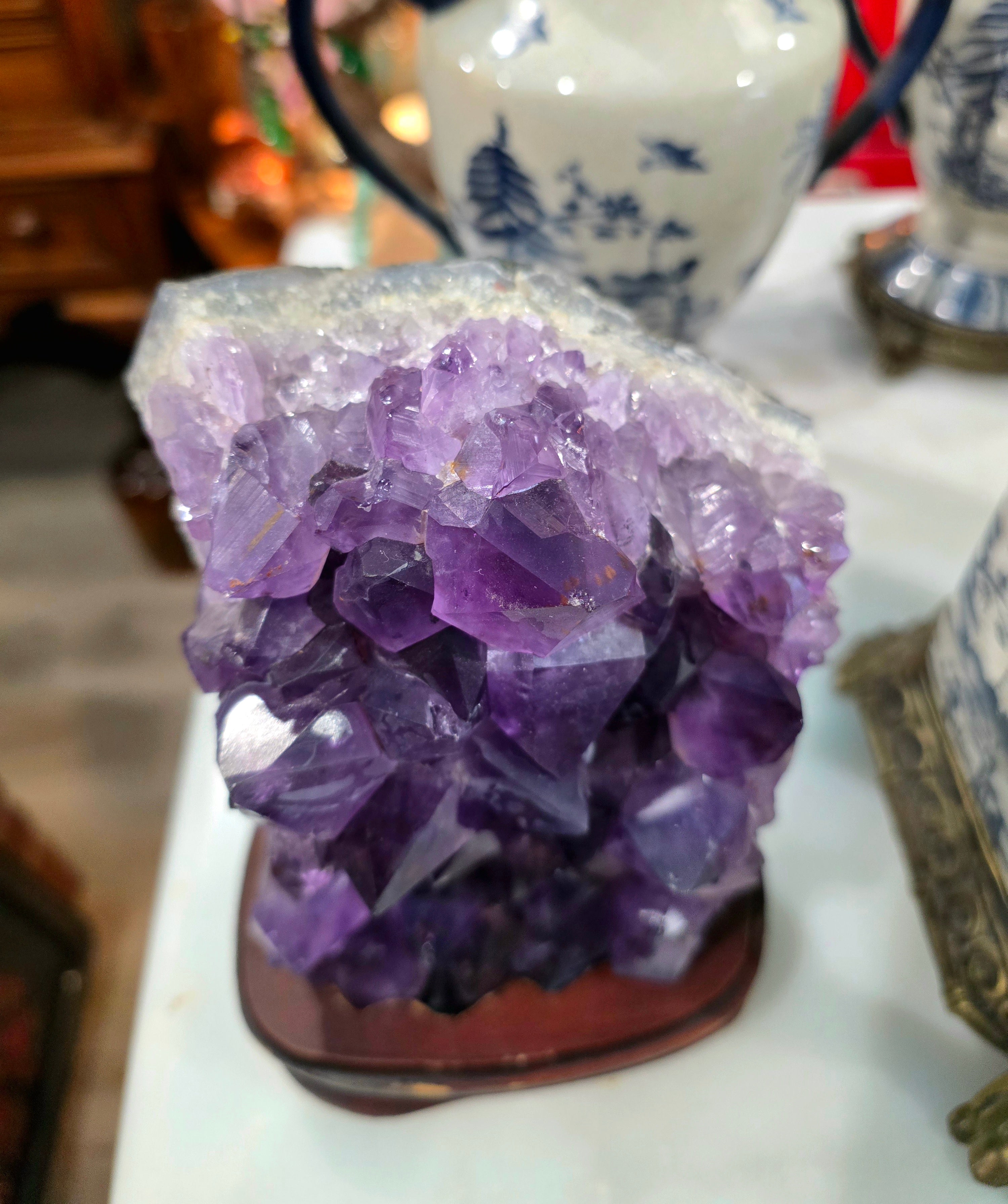Vintage amethyst crystal cluster on a wooden stand