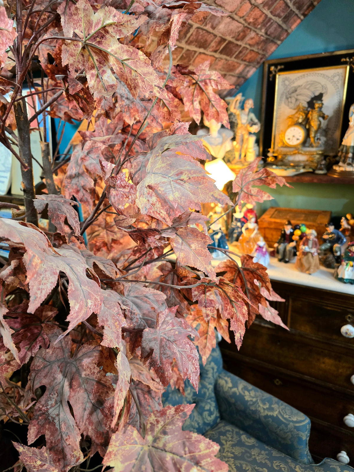 Artificial maple tree with maroon autumn-colored foliage with , blue-and-white porcelain cache-pot