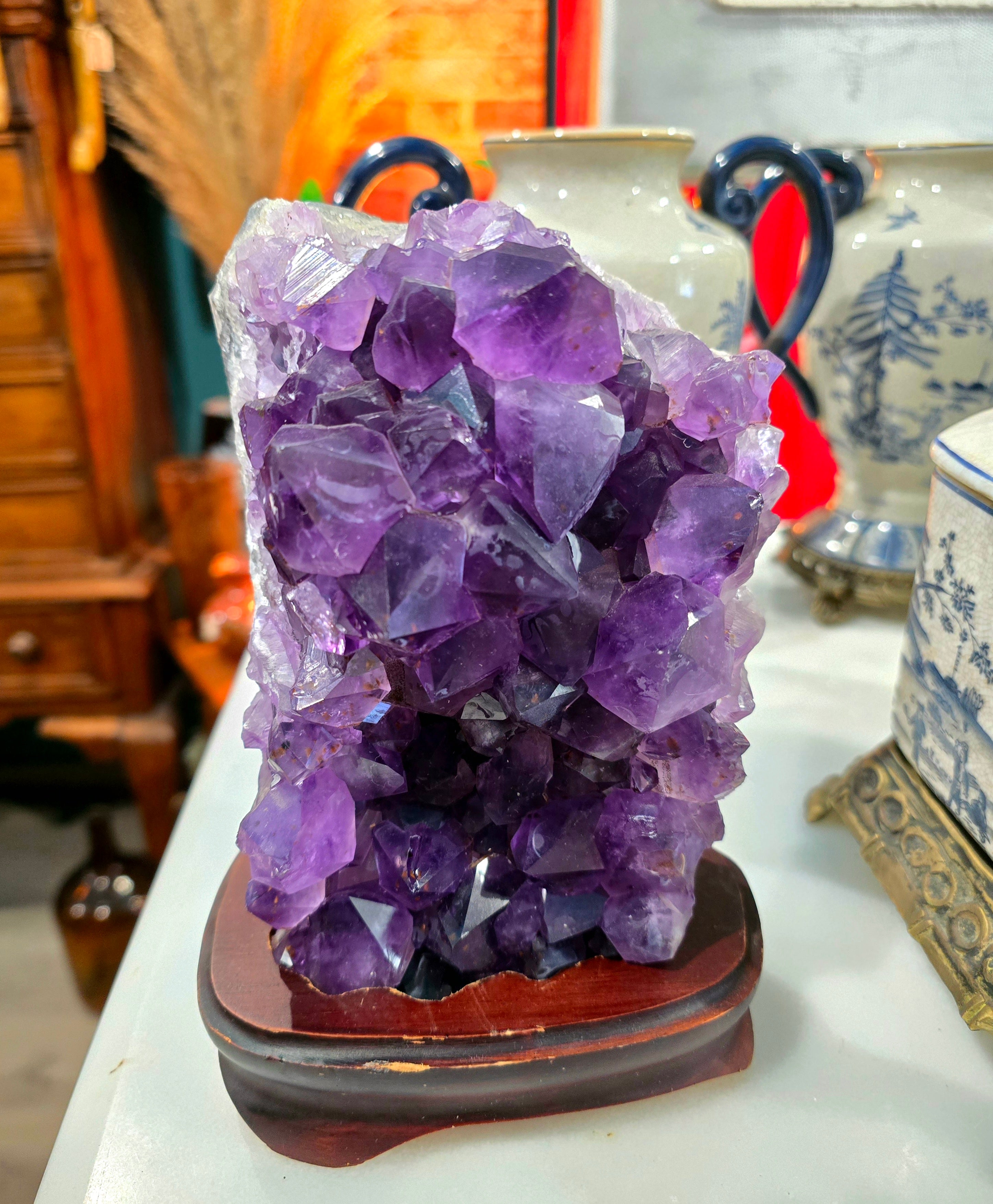 Vintage amethyst crystal cluster on a wooden stand