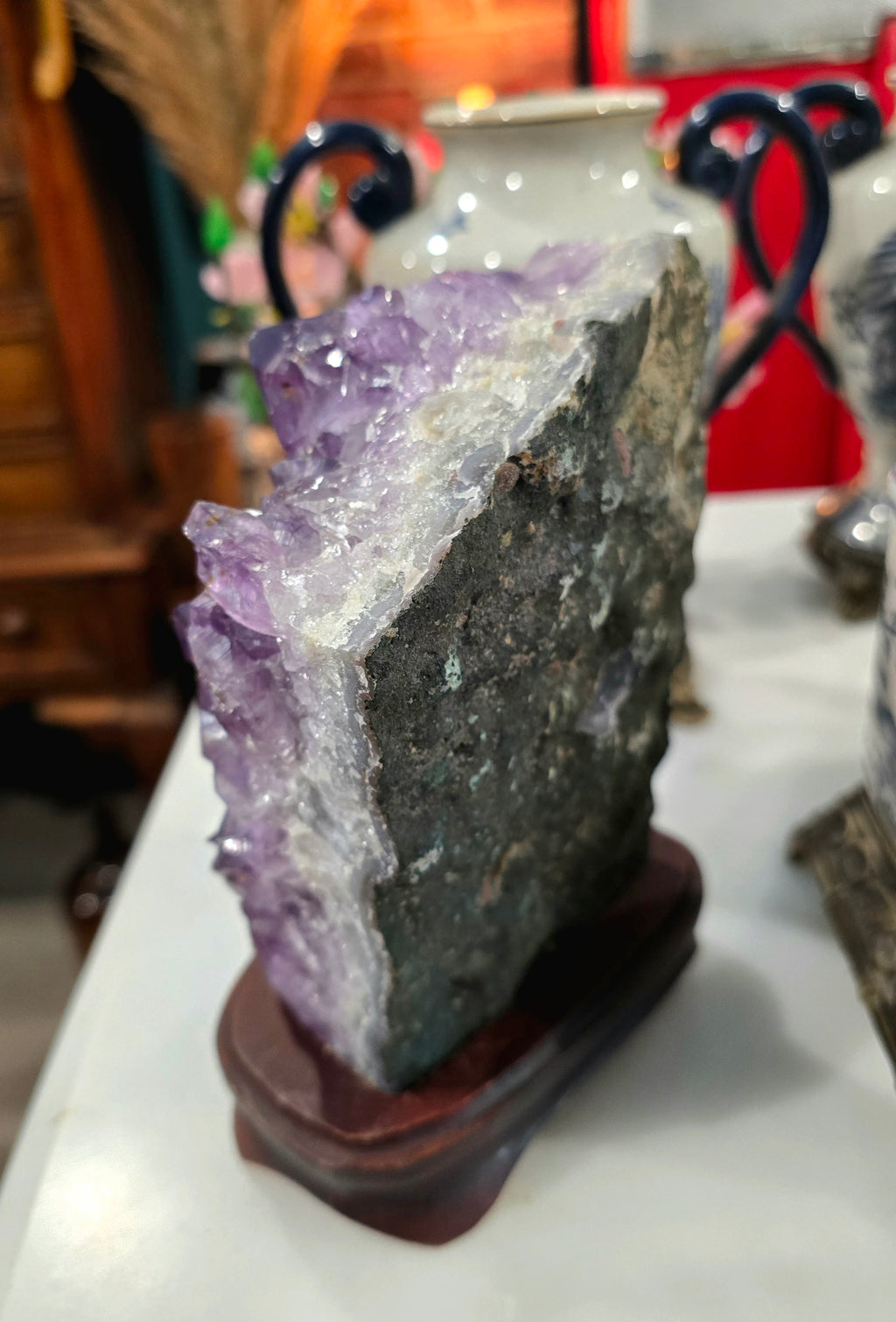 Vintage amethyst crystal cluster on a wooden stand